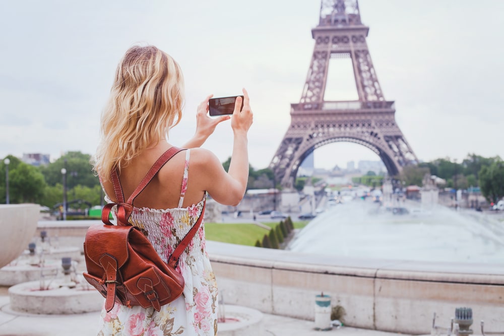 Girl taking a picture to the Eiffel Tower
