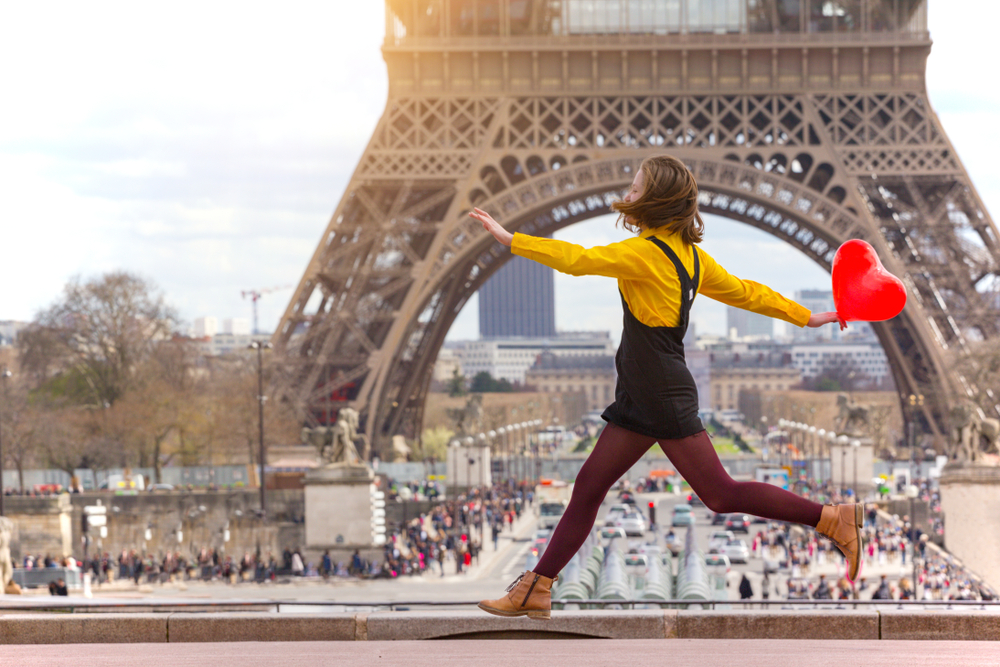 Girl jumping with red heart Eiffel Tower