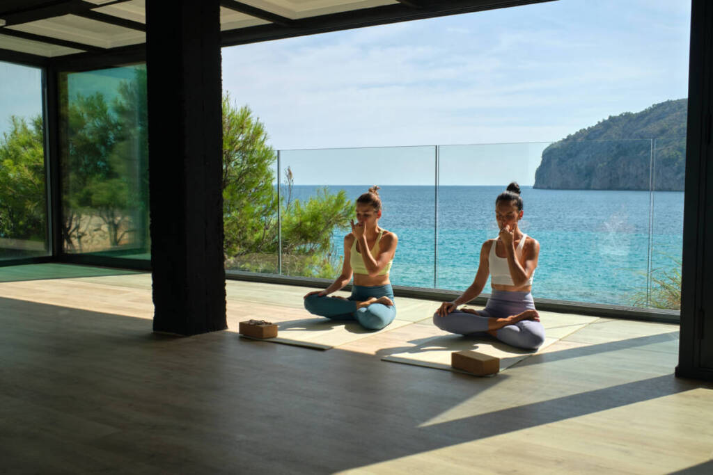Women practicing yoga with mediterranean views